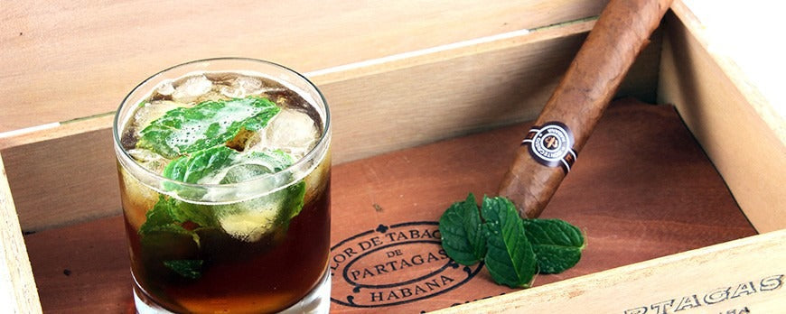 Bicchiere da cocktail con cocktail Habana, cubetti di ghiaccio, foglie di menta fresca.