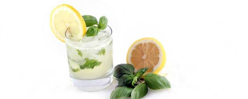 Cocktail estivo Basil Smash a base di gin, limone e basilico in un bicchiere basso.